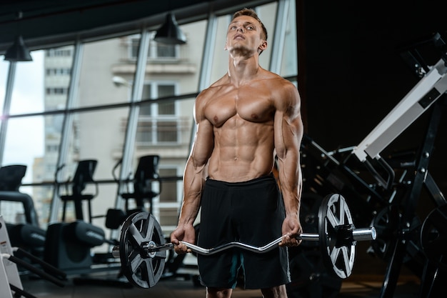 Modelo guapo joven trabajando en el gimnasio