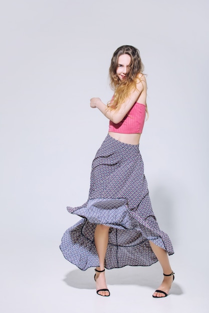 Modelo hermosa joven con cabello rubio y ojos azules en una falda y top de moda