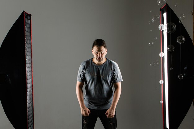 Un modelo de hombre en el estudio sobre un fondo blanco. filmación e iluminación profesional en el estudio. chico enojado