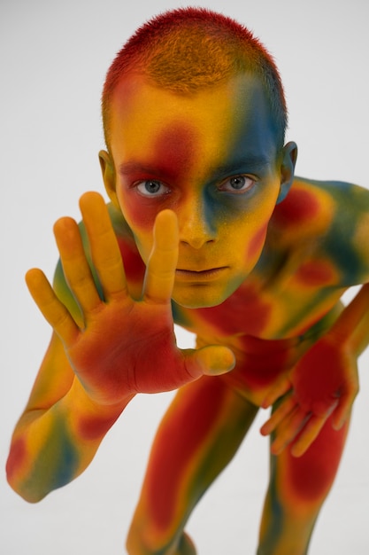 Foto modelo de hombre posando con pintura corporal colorida