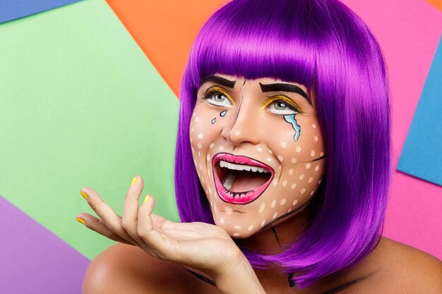 Modelo en imagen creativa con maquillaje pop art contra colores
