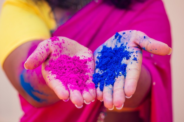 Foto modelo indio femenino sonrisa blanca como la nieve en el festival de color holi mujer india en vestido tradicional sari con cabello rizado negro en una pintura rosa y azul y joyería bindi celebrando el festival de color holi