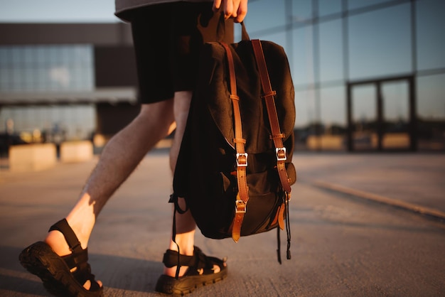 Foto modelo irreconocible con ropa informal y una famosa mochila negra ropa gris con un estilo minimalista moderno moda callejera para la temporada de primavera u otoño detalles de la apariencia cotidiana