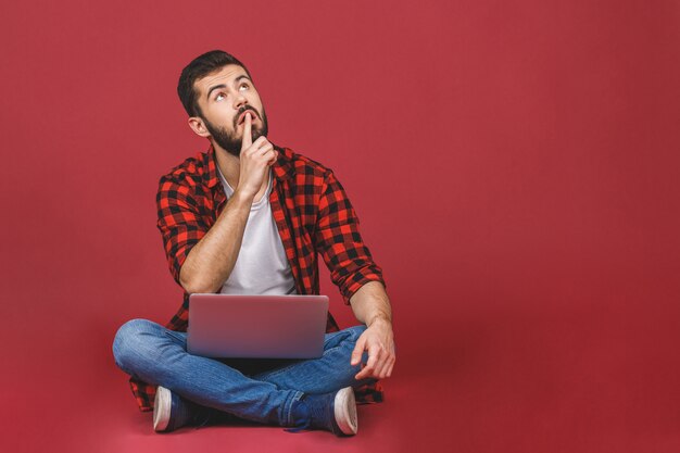 Modelo de joven estudiante masculino sentado en el piso