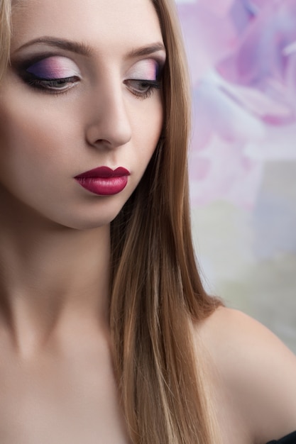 Modelo joven con maquillaje original en tonos violetas.