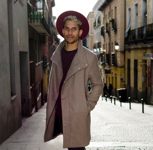 Modelo joven de moda con chaqueta gris y sombrero rojo en la calle