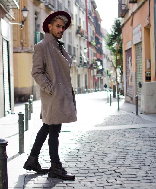 Modelo joven de moda con chaqueta gris y sombrero rojo en la calle