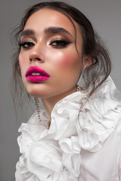 Modelo joven de moda con maquillaje profesional brillante, peinado de moda, piel perfecta