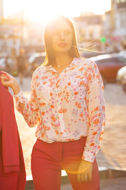 Modelo joven de moda vistiendo traje y blusa posando con la suave luz del sol de la tarde