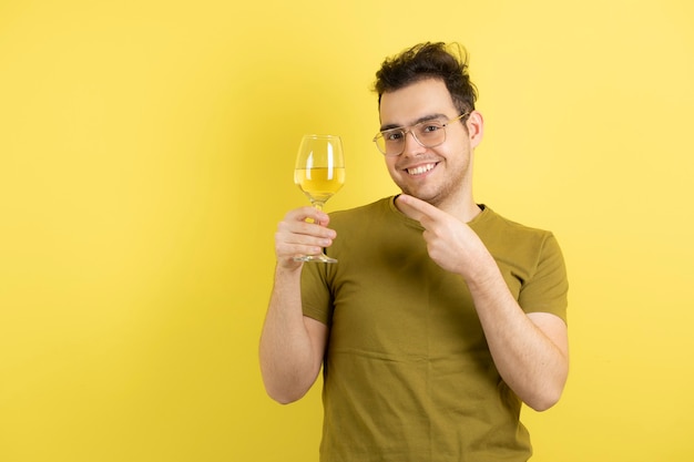 modelo joven sosteniendo una copa de vino blanco.