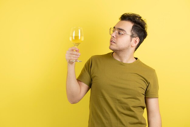 modelo joven sosteniendo una copa de vino blanco.