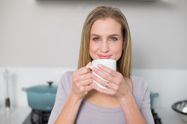 Modelo magnífico sonriente que sostiene la taza