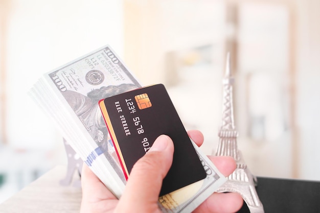 Foto modelo de mano con tarjeta de crédito o débito y billete de dólar de cerca concepto financiero y de viaje