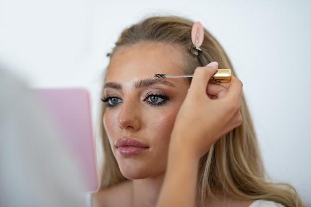 Foto modelo de maquillaje aplica polvo y sombra de ojos rubor visagiste cosméticos maquillaje de belleza joven modelo g