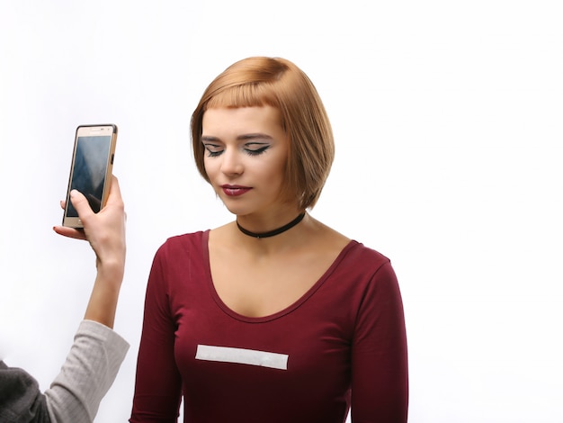 Modelo con maquillaje fotografiado en teléfono inteligente