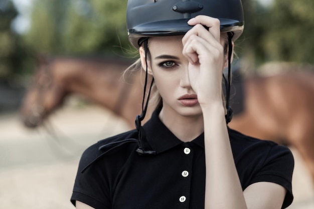 Modelo con maquillaje perfecto sostiene un casco con una mano