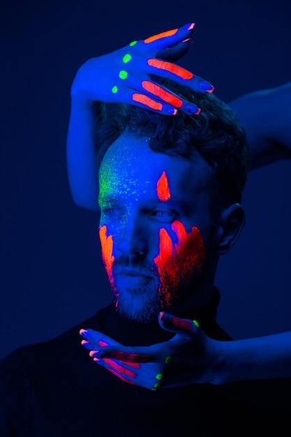 Modelo masculino caucásico con pintura de luz negra