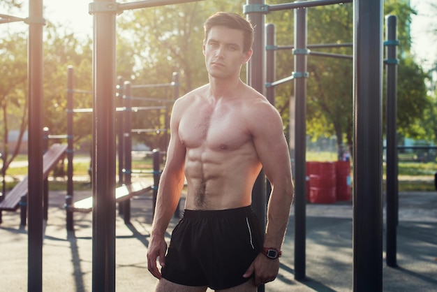 Modelo masculino de aptidão muscular posando sem camisa, demonstrando seis packs abs