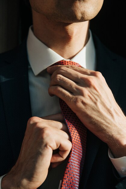 Modelo masculino de terno preto e gravata vermelha posa para publicidade de roupas masculinas. Tiro para loja de roupas masculinas