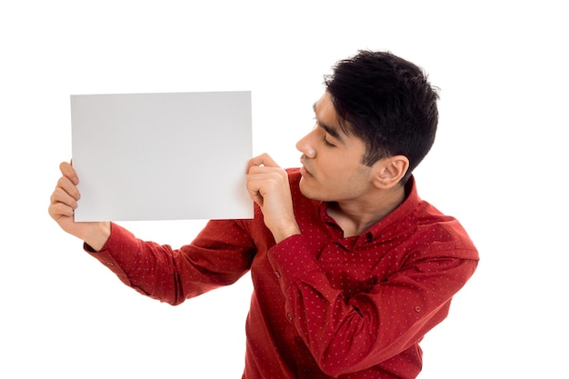 Modelo masculino guapo joven posando con cartel en manos aisladas sobre fondo blanco