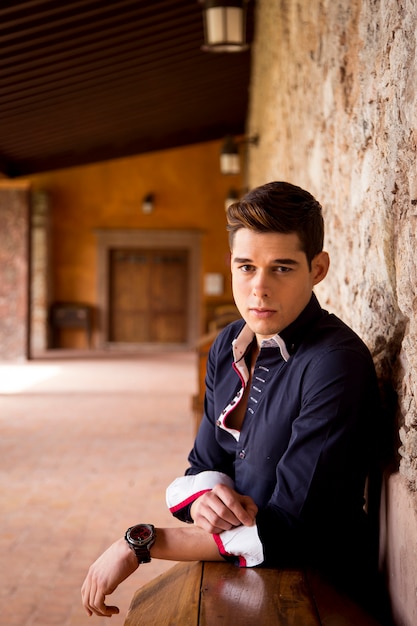 Foto modelo masculino joven atractivo que presenta al aire libre, con camisa casual y reloj