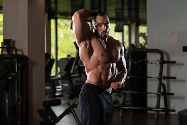 Modelo masculino musculoso posando en el gimnasio