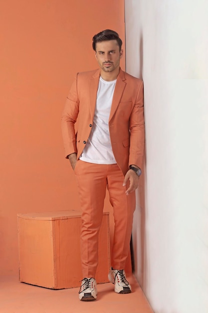 Modelo masculino posando em terno laranja