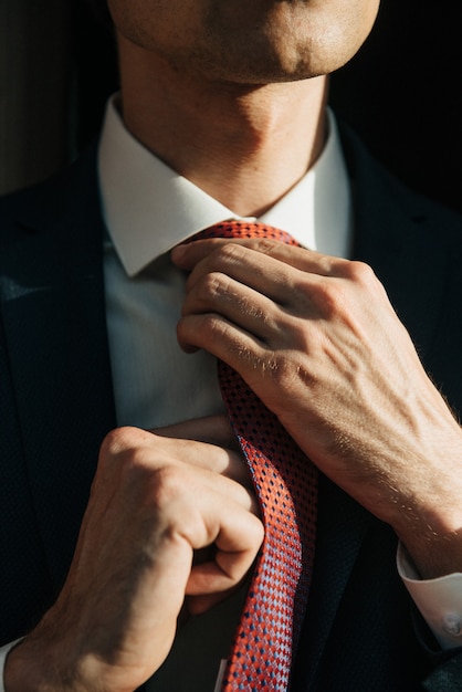 Modelo masculino en traje negro y corbata roja posa para publicidad de ropa para hombres. Tiro para tienda de ropa masculina