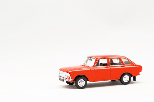 Modelo en miniatura de un coche retro rojo sobre una superficie blanca