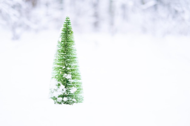 Modelo en miniatura de pino de invierno en la nieve. Fondo de Navidad