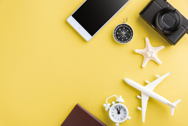 modelo mínimo de avión, avión, estrella de mar, reloj despertador, brújula y pantalla en blanco de teléfono inteligente