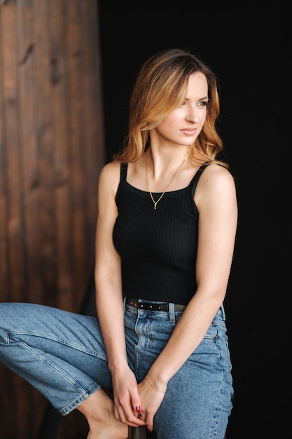 Modelo de moda en denim y camiseta negra en estudio