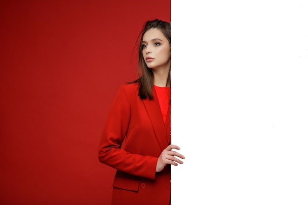 Modelo de moda en falda de chaqueta de traje rojo Hermosa mujer joven Fondo rojo