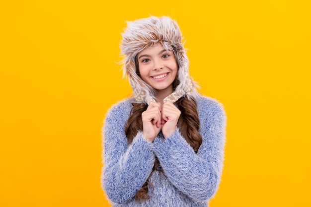 Modelo de moda femenina jovencita en géneros de punto sobre fondo amarillo retrato de niño