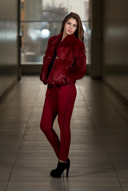 Modelo de moda de glamour con chaqueta y pantalones rojos