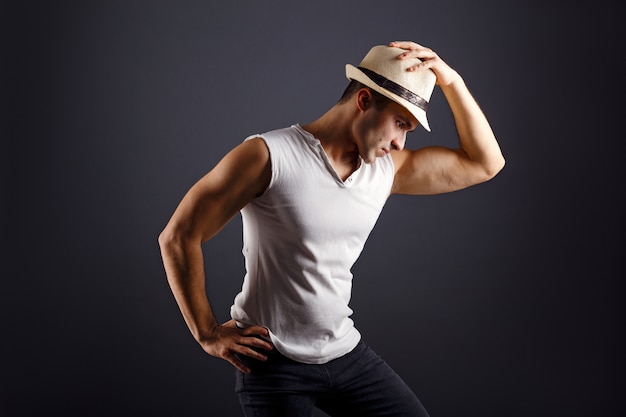 Modelo de moda hombre, elegante joven con sombrero fedora de pie