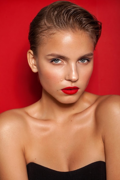 Modelo de moda joven con look de fiesta de labios rojos