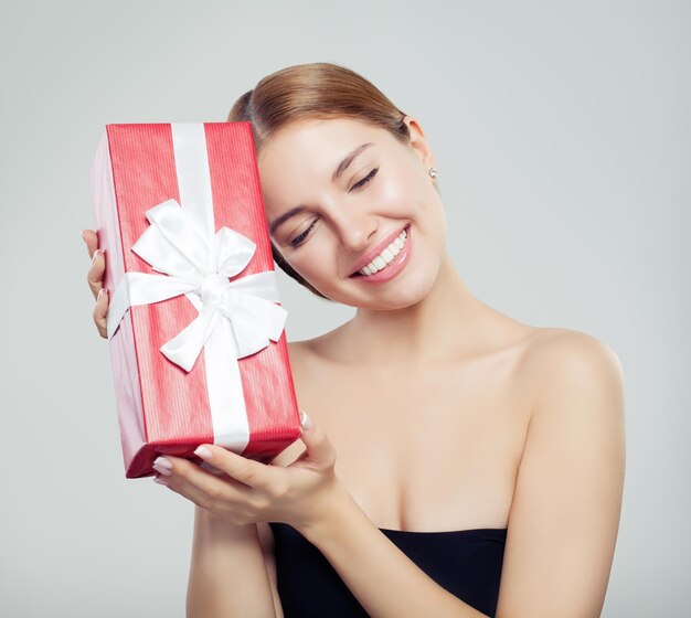 Modelo de moda de mujer alegre con regalo y sonriendo