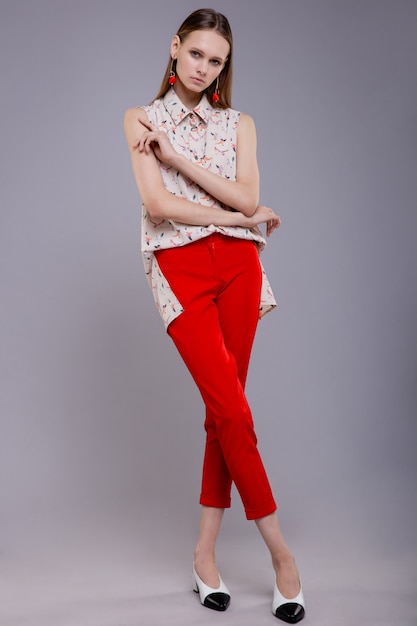 Modelo de moda en pantalones rojos sin mangas superior estampados hermosa mujer joven Foto de estudio