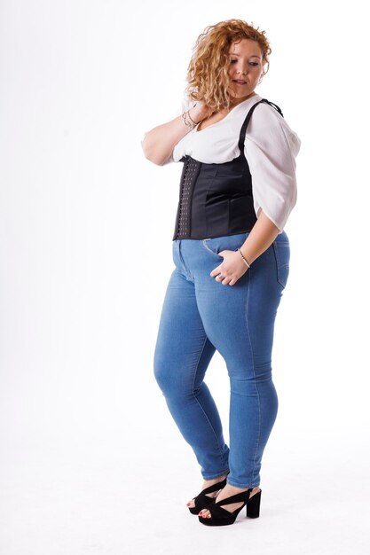 Foto modelo de moda de talla grande mujer gorda en ropa de mezclilla y camisa blanca sobre fondo blanco cuerpo femenino con sobrepeso