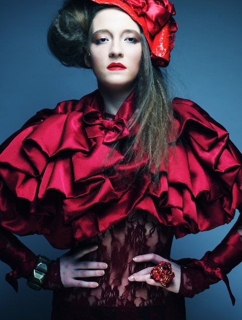 Modelo de moda en traje rojo brillante y sombrero rojo. Tiro del estudio.