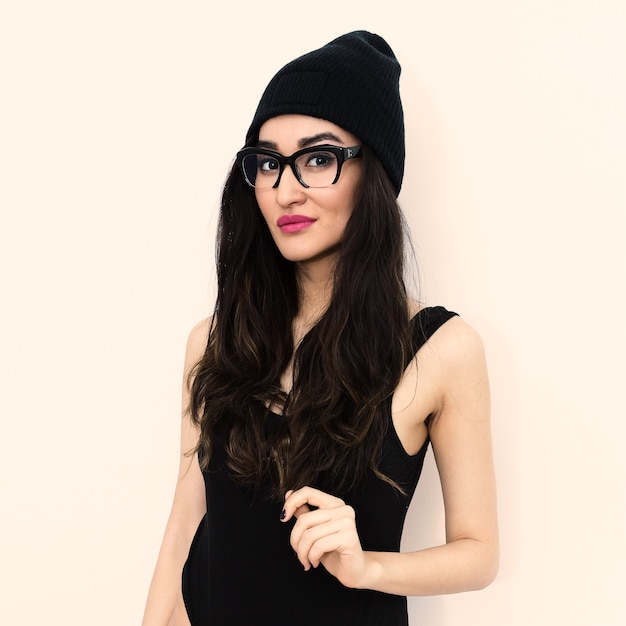 Modelo morena com gorro da moda e óculos elegantes estilo Swag