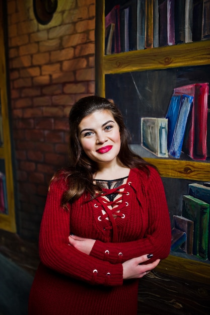 Modelo morena contra la pared como biblioteca.