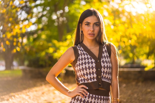 Modelo morena en otoño al atardecer en un parque natural de la ciudad con el sol de fondo