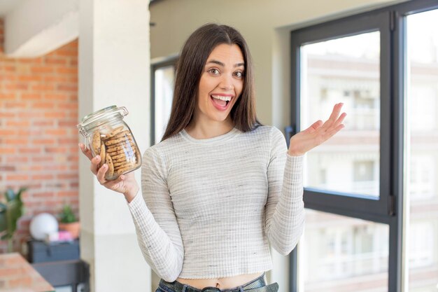 Foto modelo muito jovem, sentindo-se feliz e surpreso com algo inacreditável conceito de biscoitos caseiros