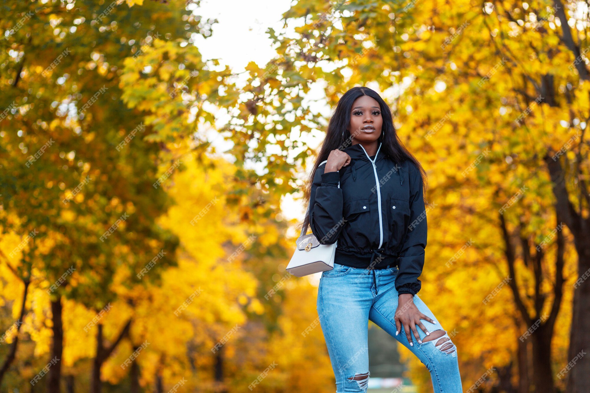 de mujer americana negra de moda en elegante chaqueta casual jeans camina en el increíble parque de otoño con hojas amarillas de otoño | Foto Premium