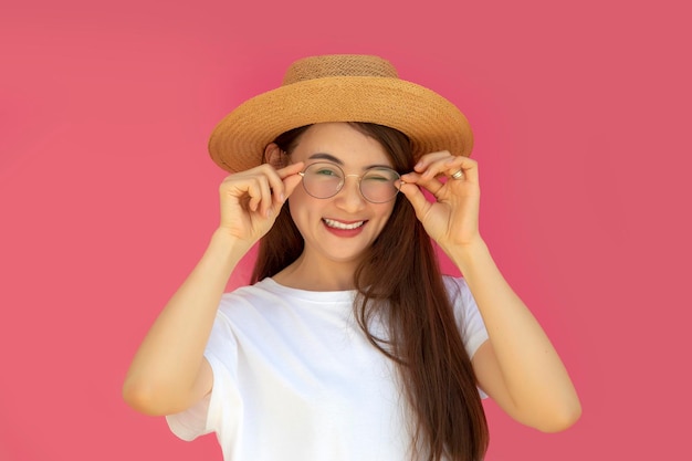 modelo de mujer asiática sonrisa feliz con sombrero sobre fondo rosa aislado en cartelera en blanco poner promoción de texto y exhibición de productos para publicidad