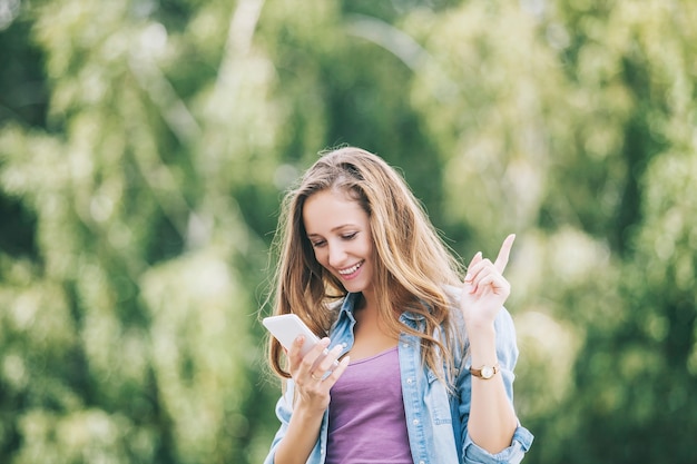 Modelo de mujer hermosa con teléfono inteligente fuera de teléfono móvil