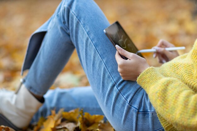 Modelo de mujer joven en el parque de otoño con hojas de arce de follaje amarillo Moda de temporada de otoño