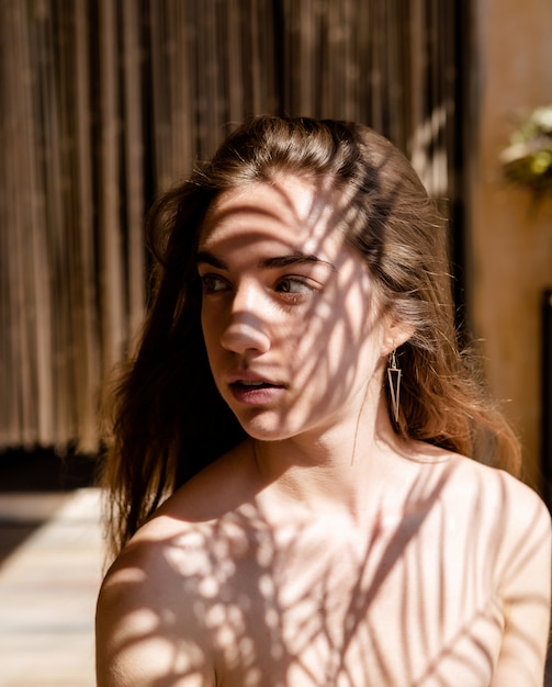 Modelo de mujer joven con sombras en su rostro. Luz y sombra. interesante retrato de la cara de una niña cubierta con una sombra inusual.